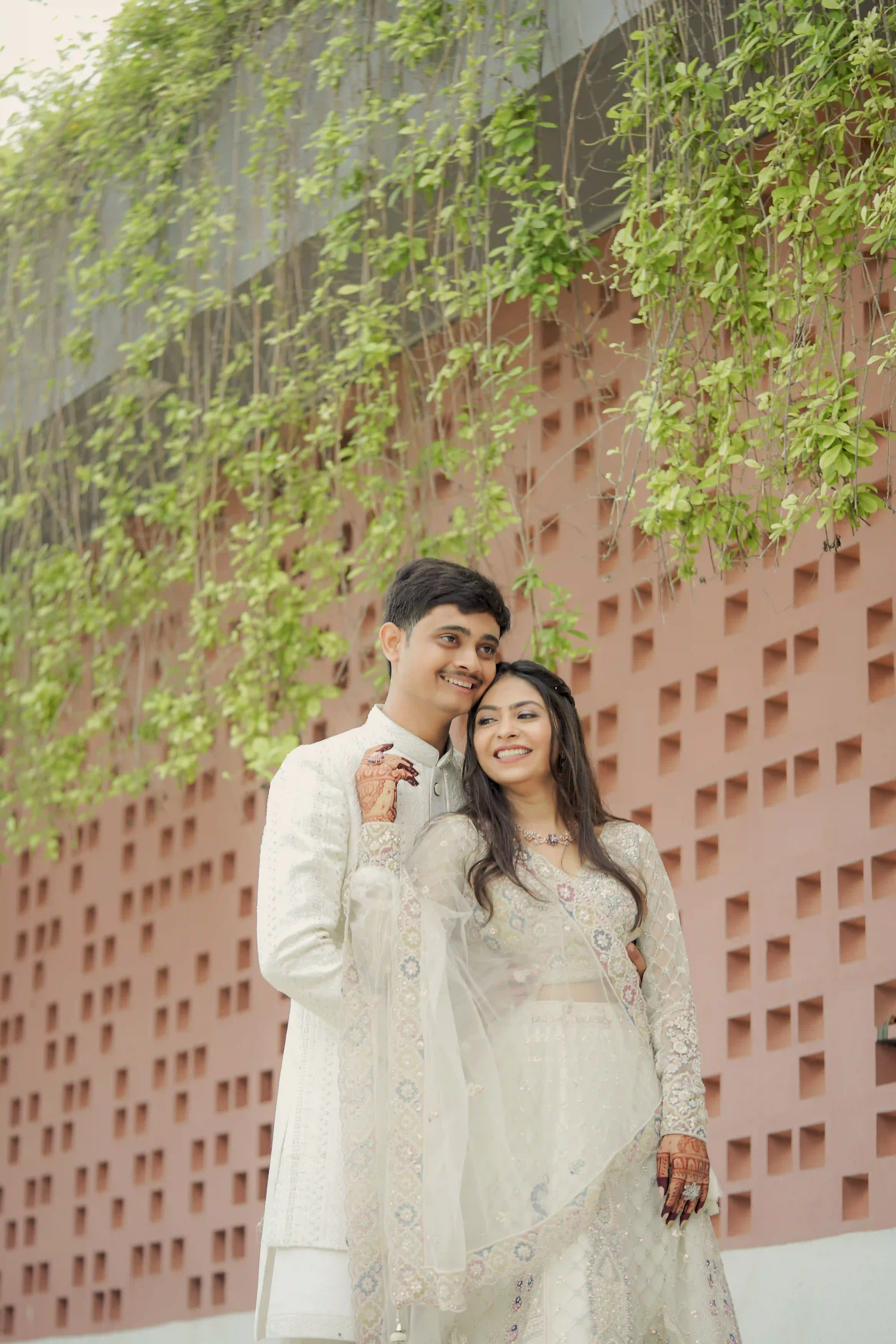 Newlywed couple posing together in traditional white wedding attire